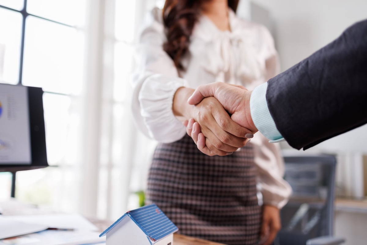 Property manager shaking hands with a client at the office