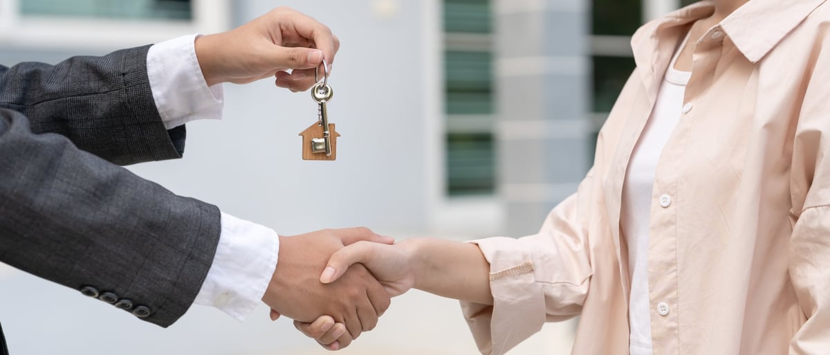 Property manager handing new keys to a happy resident